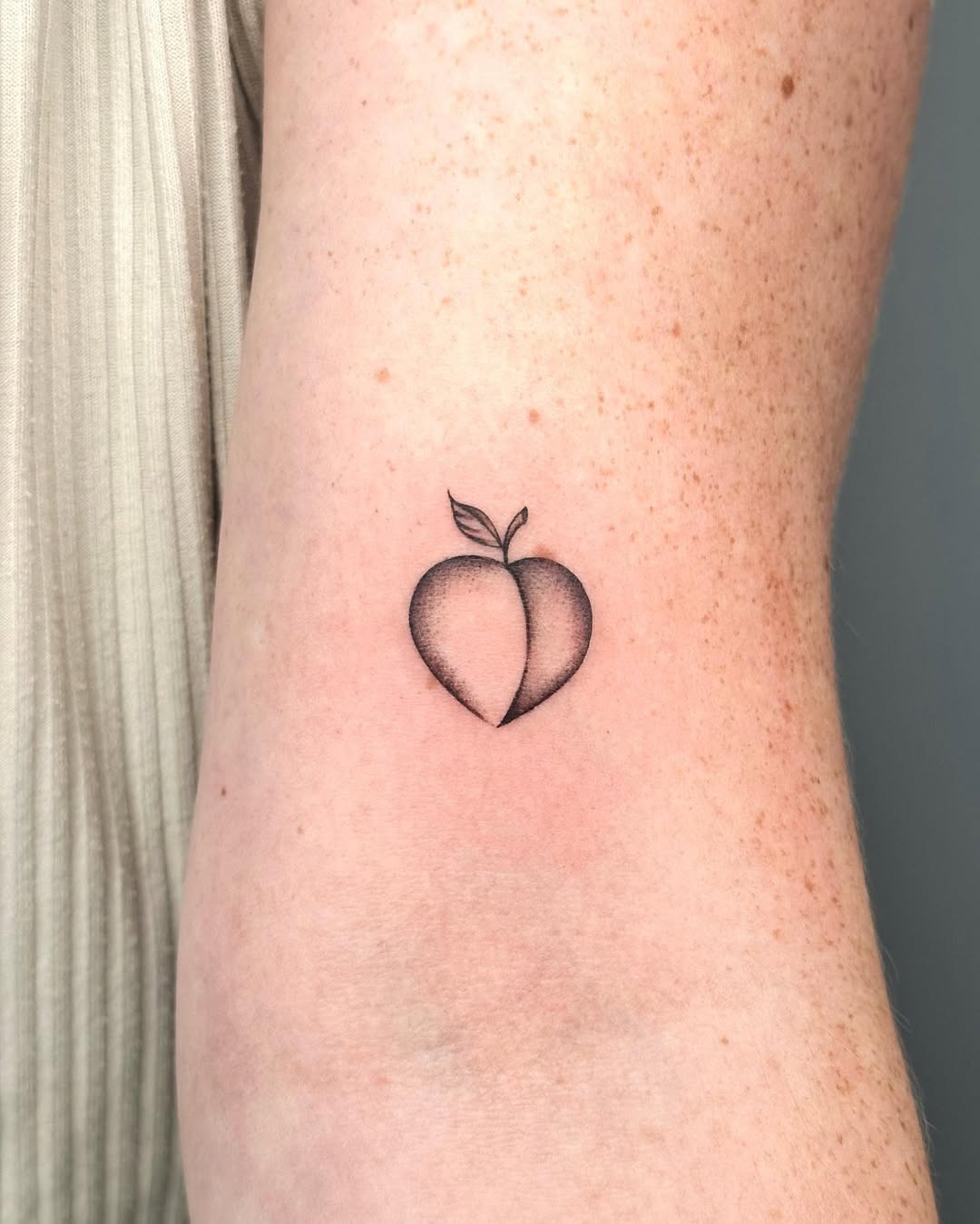 Minimalist peach tattoo with subtle detailing Tattoo Design