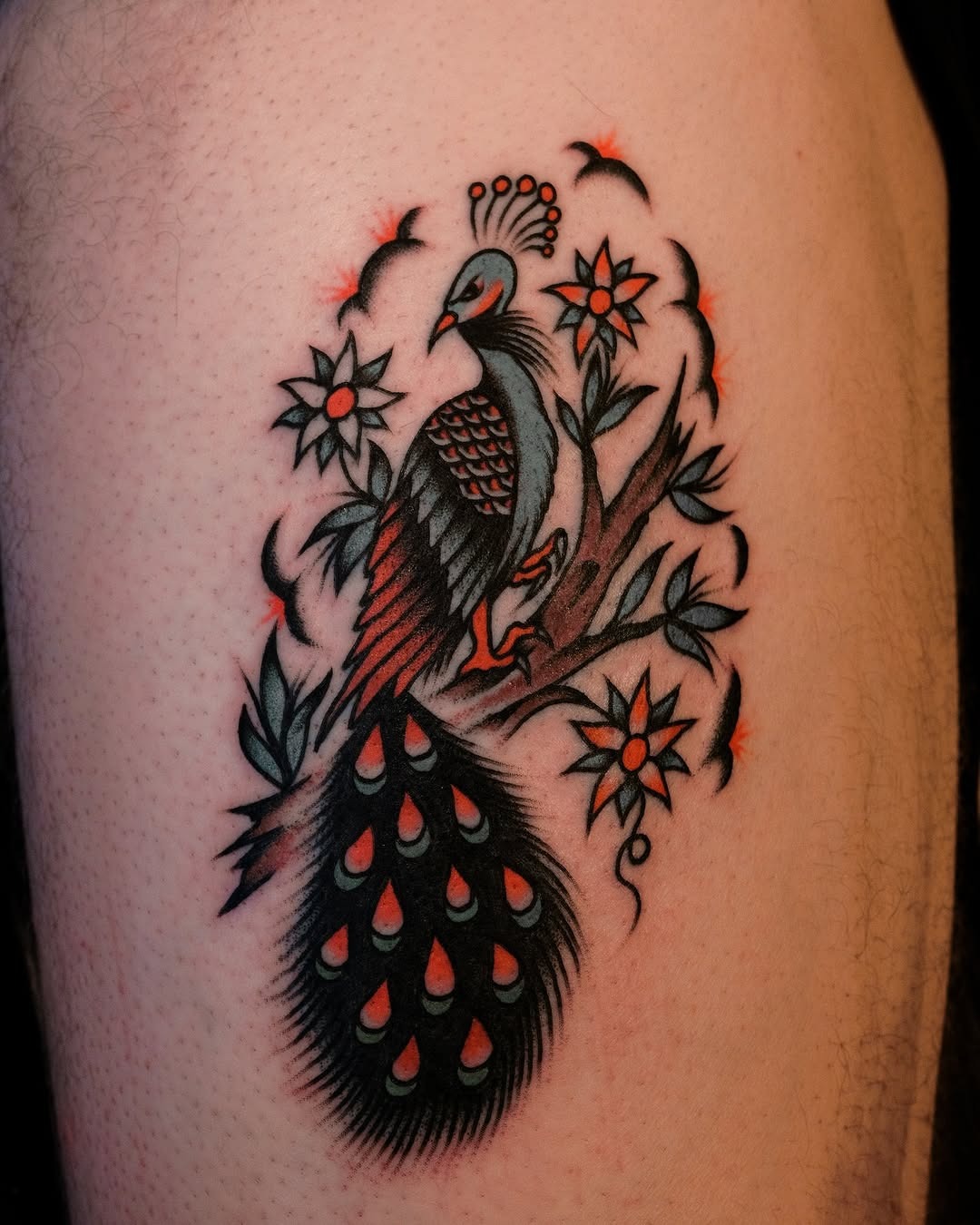 Colorful peacock tattoo surrounded by floral elements Tattoo Design