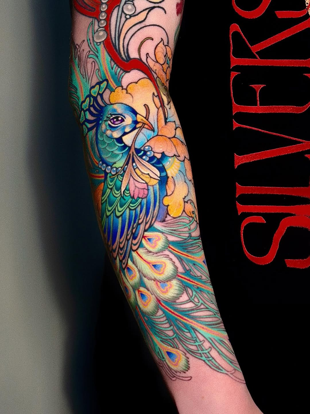 Stunningly vibrant peacock tattoo on forearm Tattoo Design