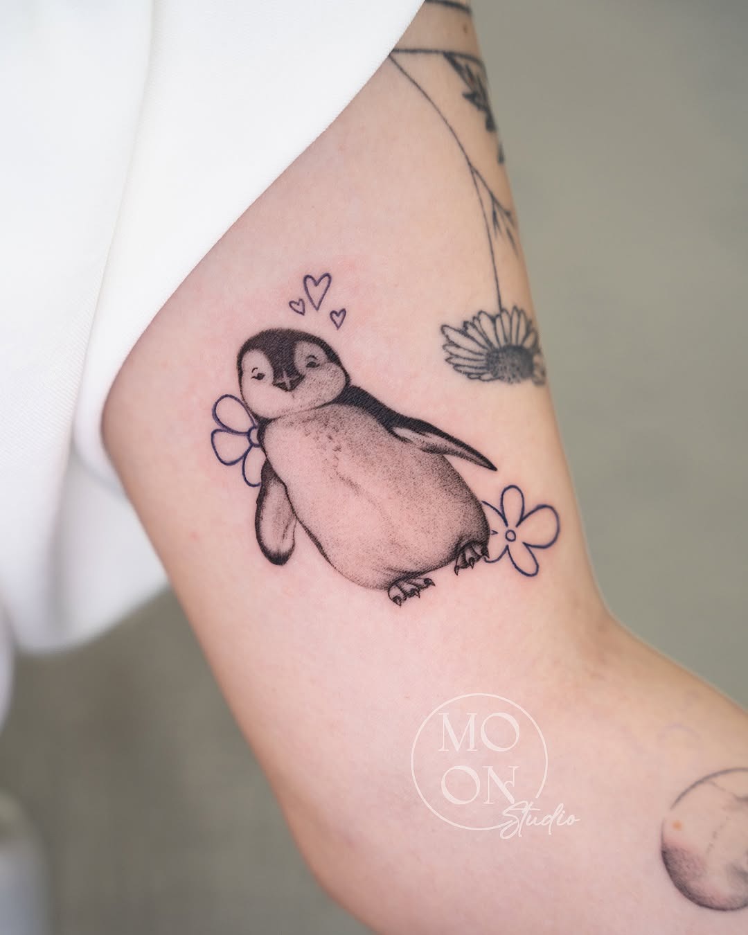 Adorable penguin tattoo with floral elements Tattoo Design