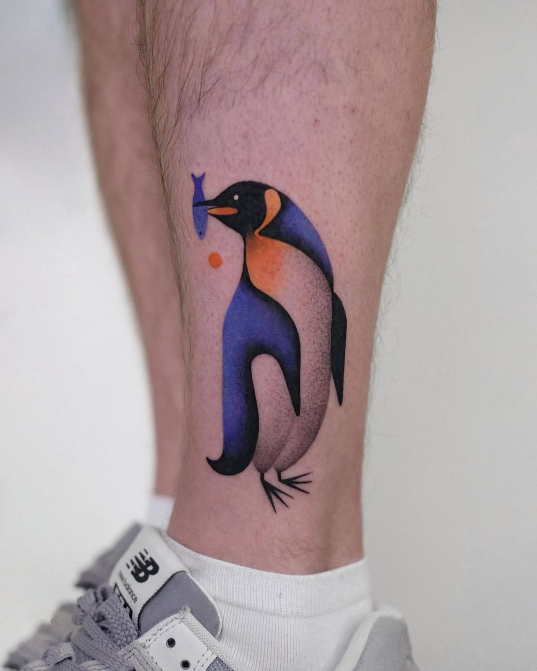 Vibrant artistic penguin tattoo with fish Tattoo Design