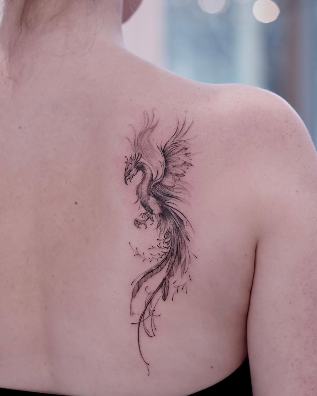 Elegant phoenix tattoo soaring on the back. Tattoo Design