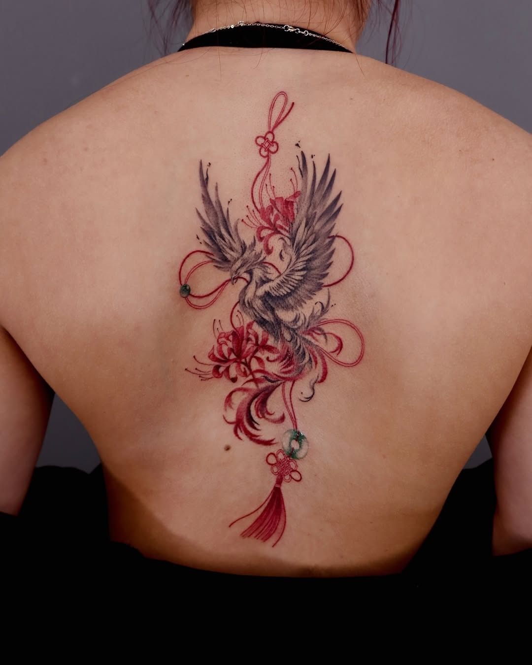 Elegant phoenix tattoo surrounded by floral motifs. Tattoo Design