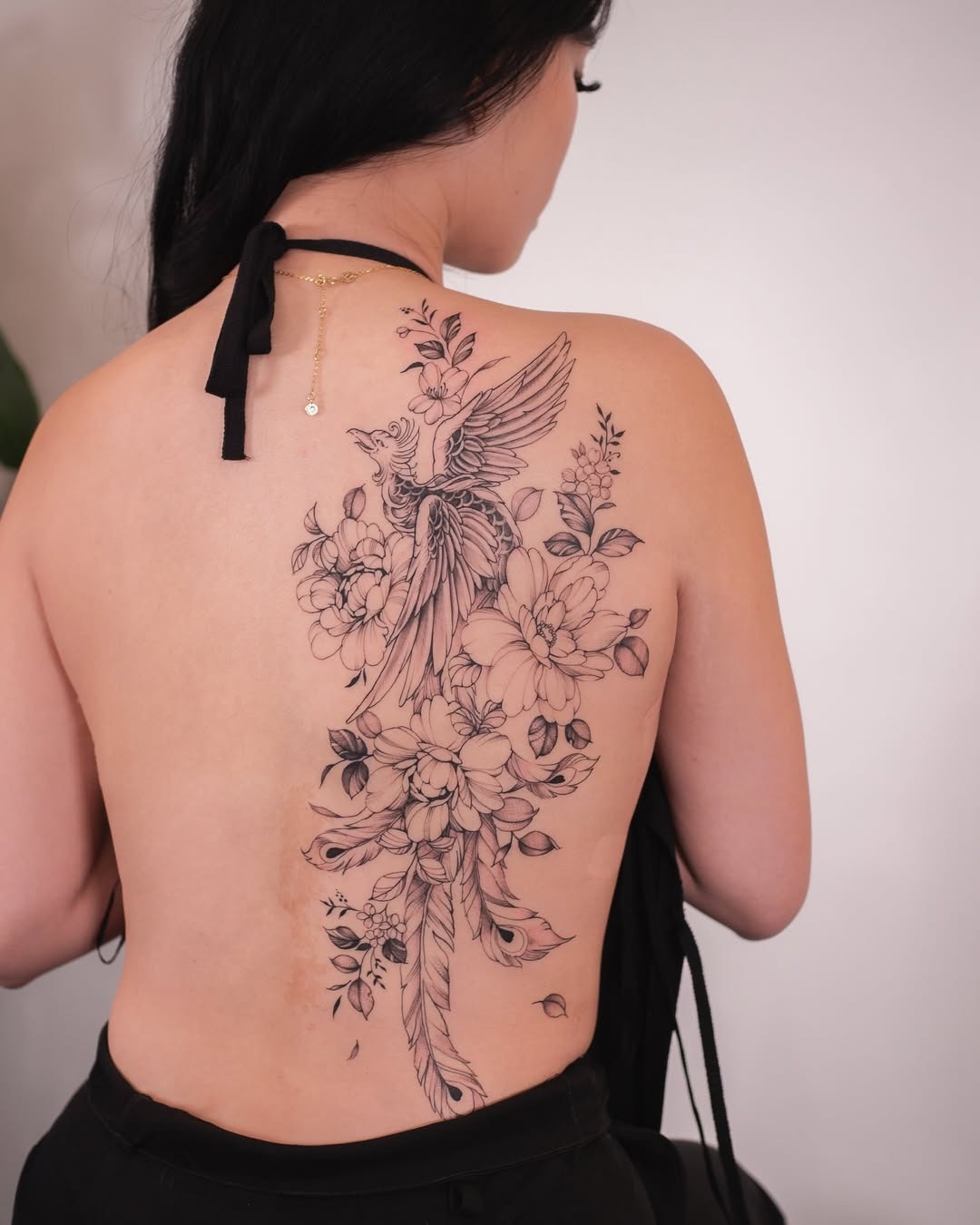 Elegant phoenix tattoo with floral elements Tattoo Design