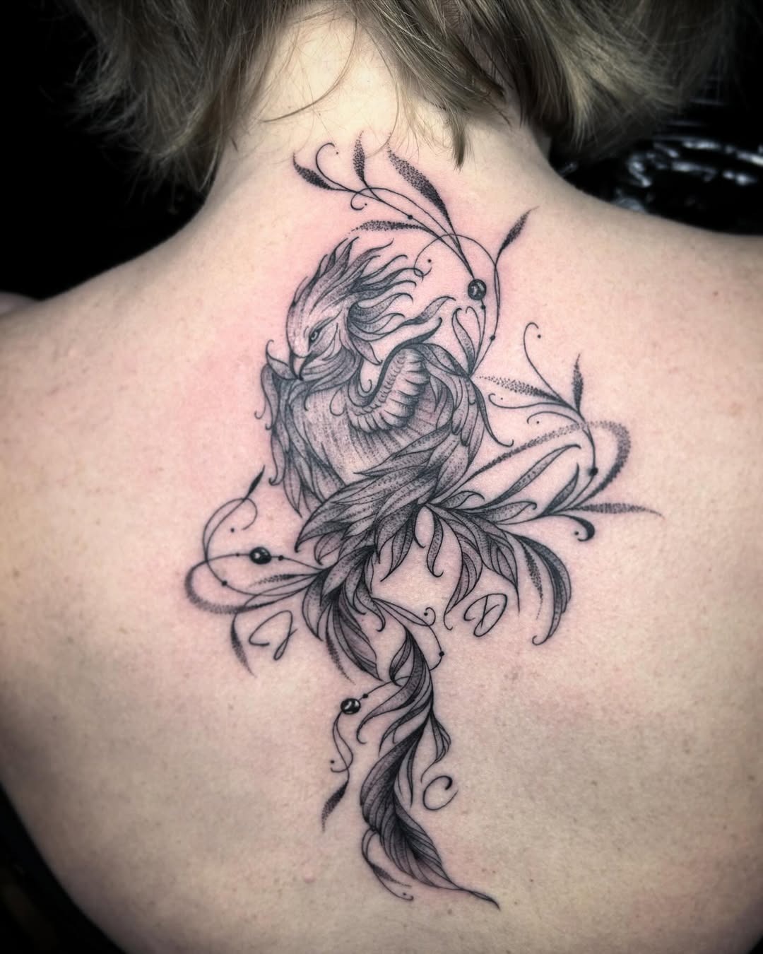 Elegant phoenix tattoo with floral elements Tattoo Design