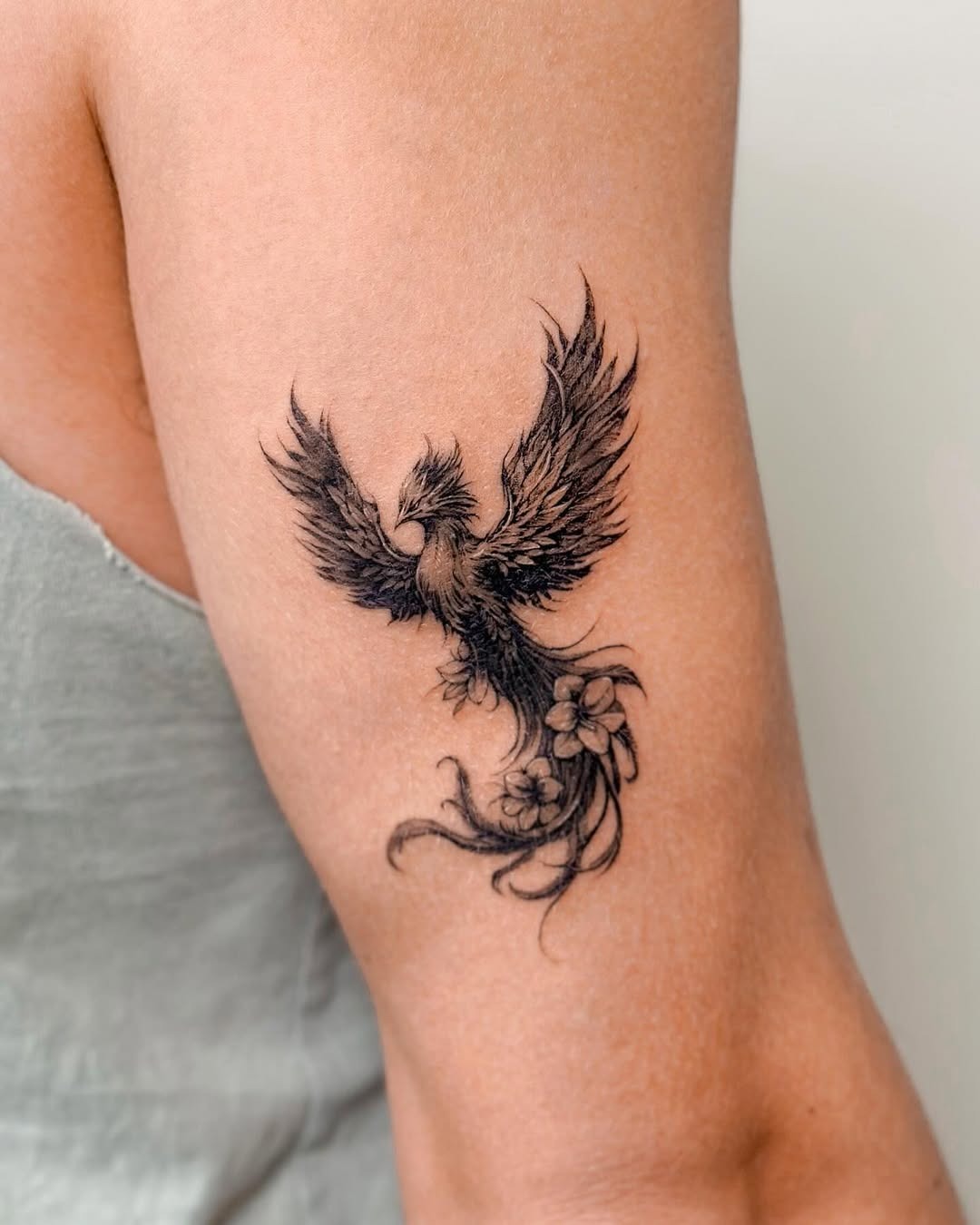 Elegant phoenix tattoo with floral elements Tattoo Design