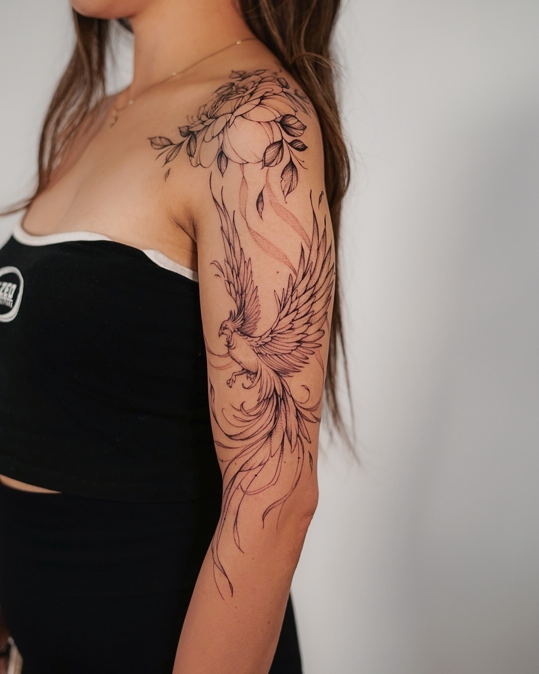 Elegant phoenix tattoo with floral embellishments Tattoo Design