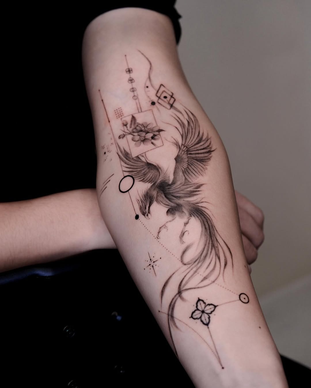 Elegant phoenix with floral accents and geometric details Tattoo Design