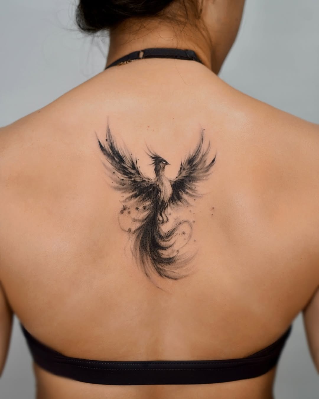 Stunning black ink phoenix tattoo on back Tattoo Design