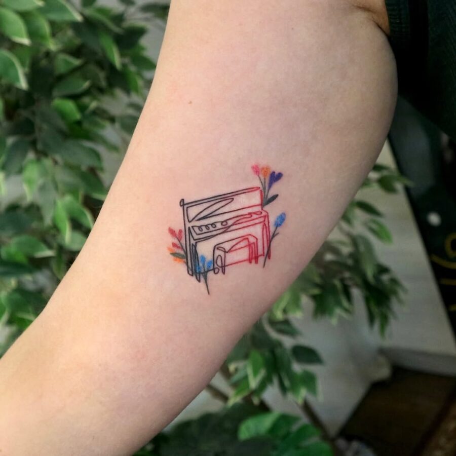 A vibrant piano tattoo surrounded by flowers Tattoo Design