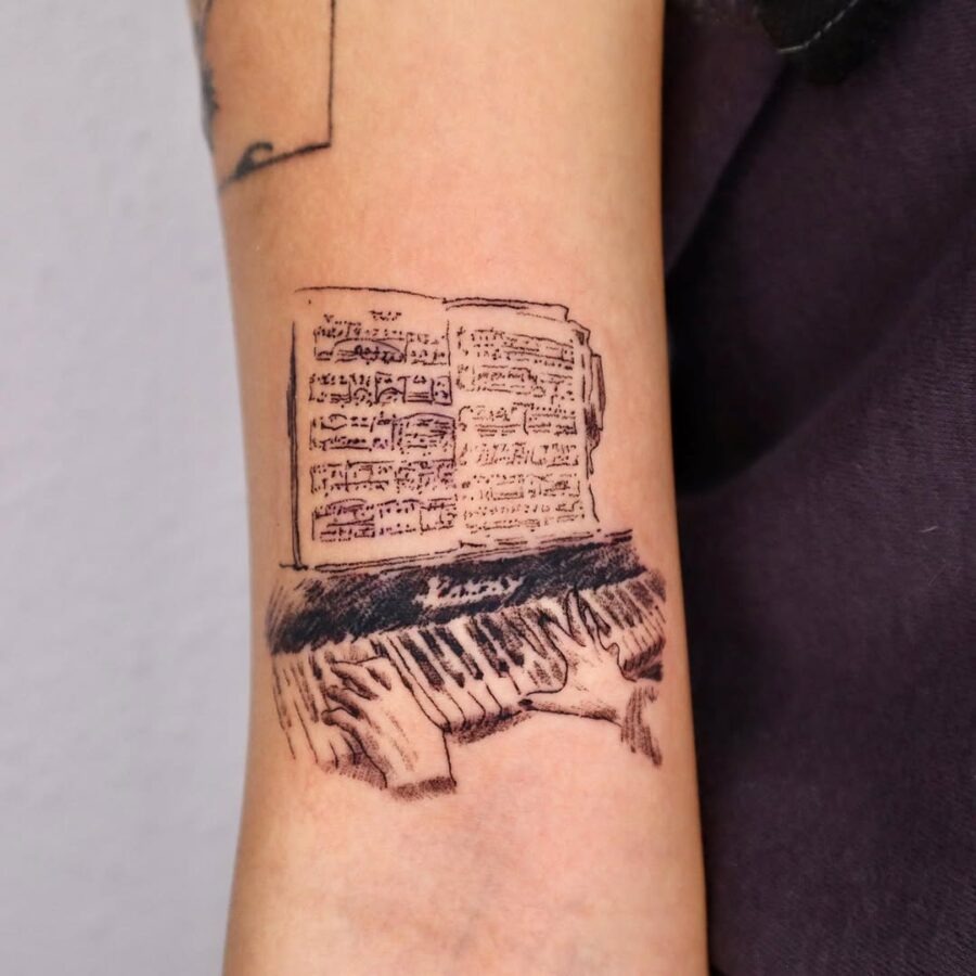 Detailed piano tattoo with sheet music illustration Tattoo Design