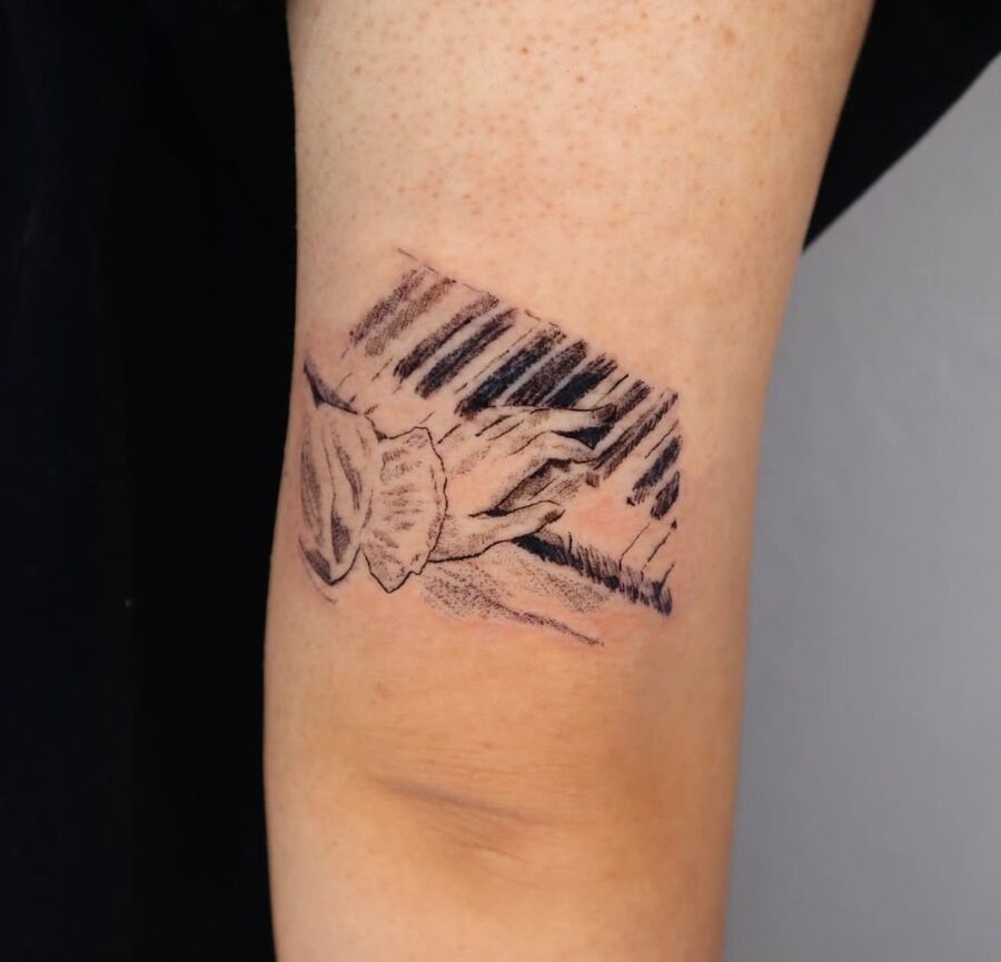 Intricate piano tattoo showcasing hands in harmony Tattoo Design