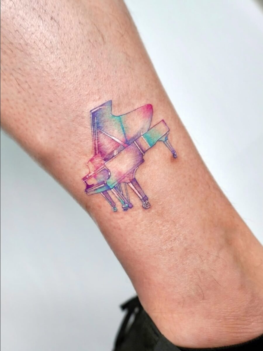 Vibrant grand piano tattoo on the leg Tattoo Design