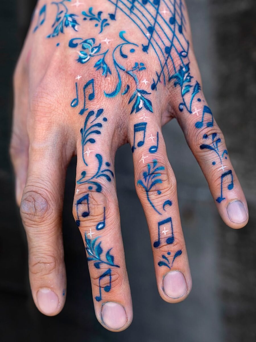 Vibrant Musical Note Tattoos Adorning a Hand Tattoo Design