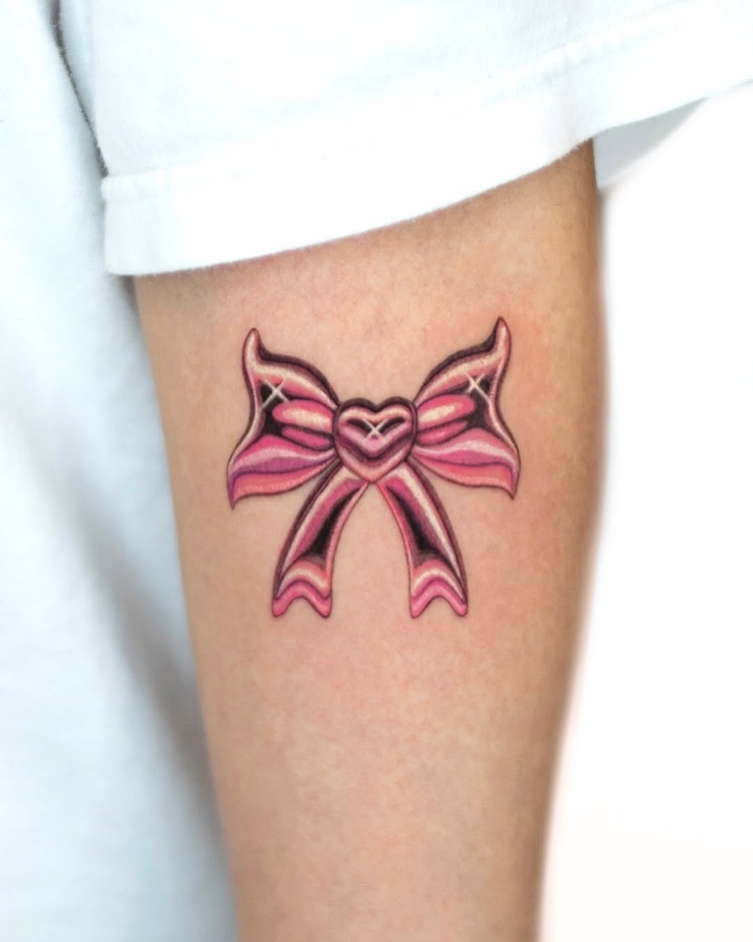 Charming pink bow tattoo with heart detail Tattoo Design