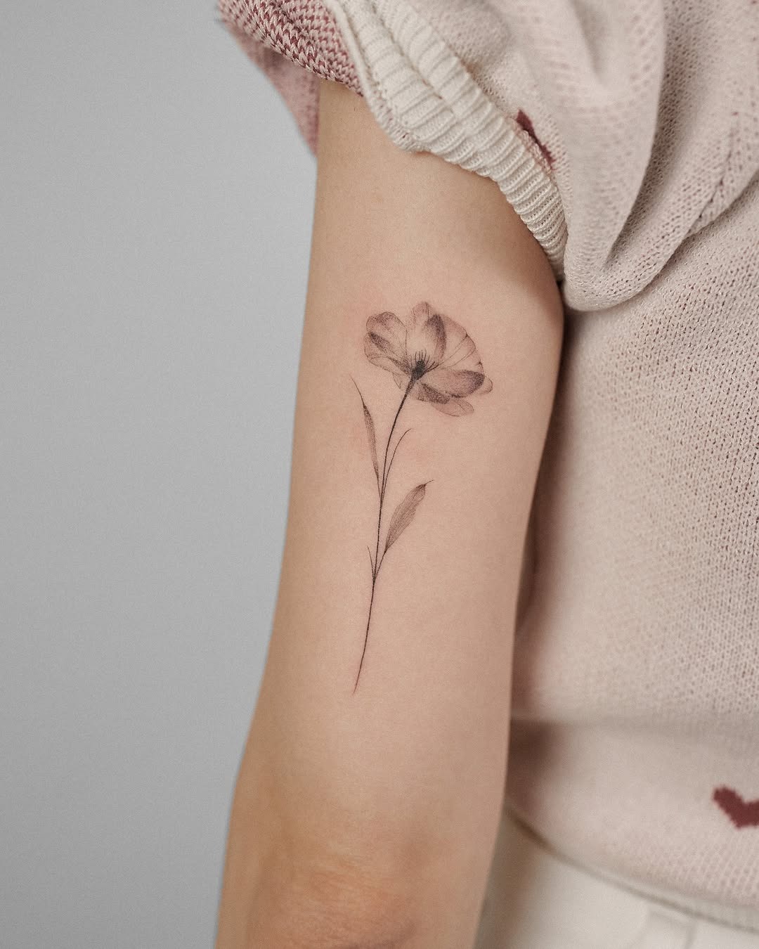 Delicate poppy tattoo showcases minimalist floral art Tattoo Design