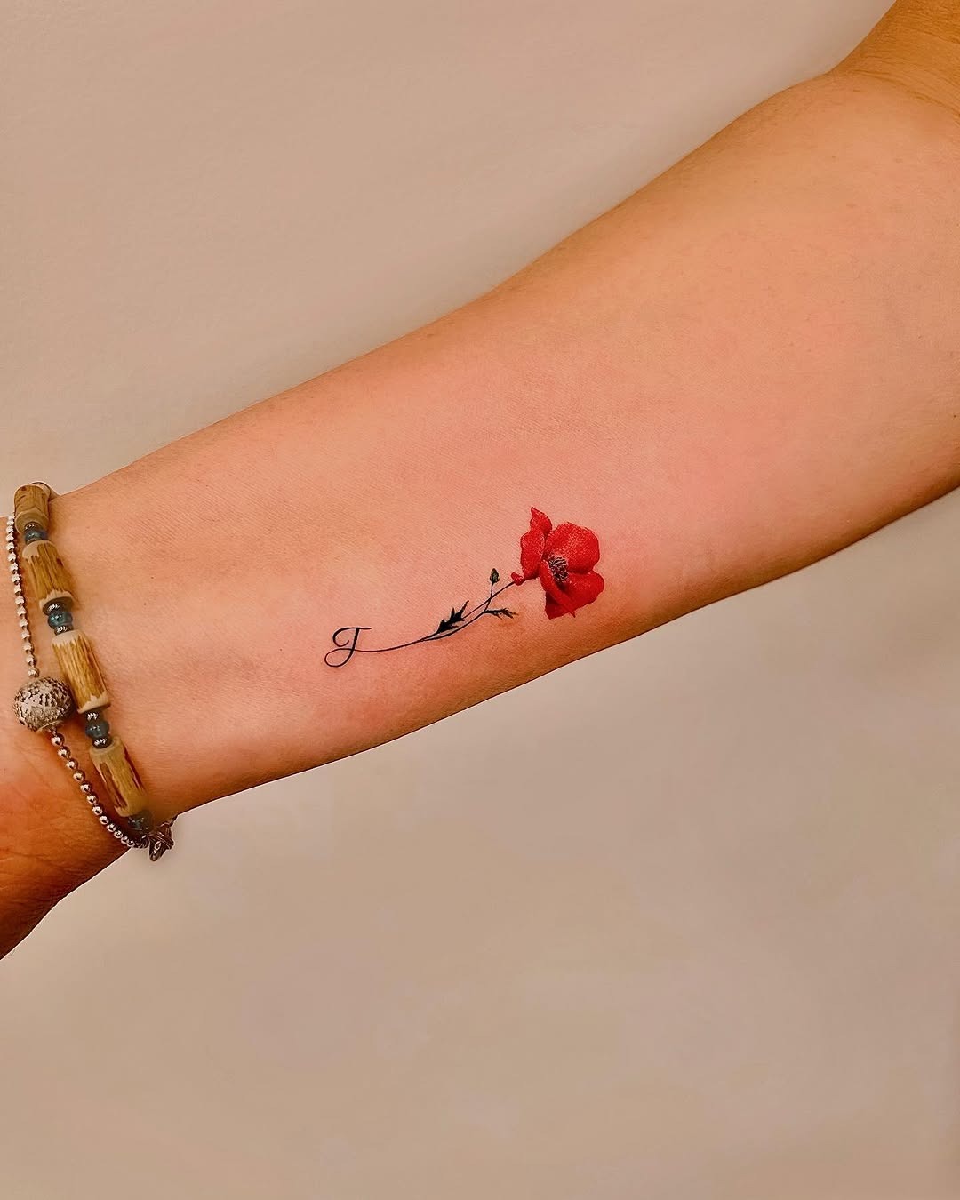 Elegant poppy tattoo on a delicate arm Tattoo Design