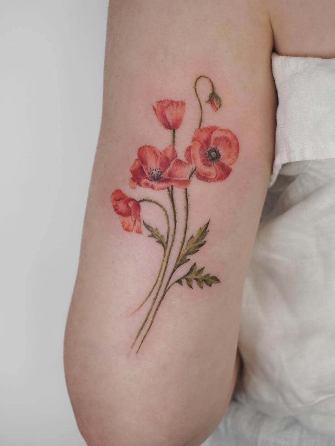 Elegant poppy tattoo with delicate floral details Tattoo Design