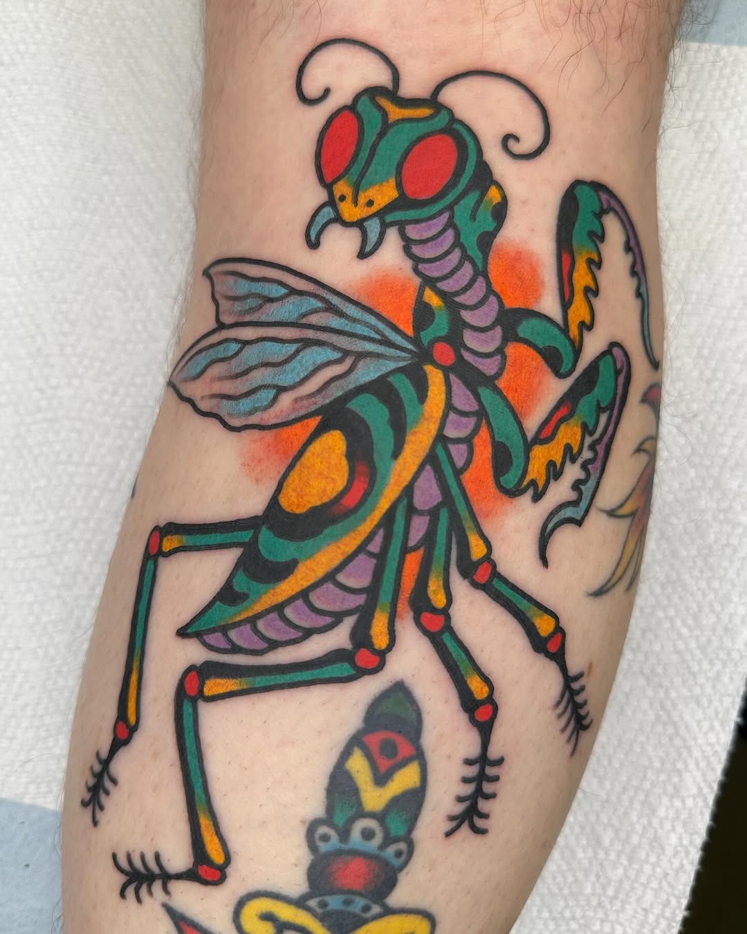 Vibrant praying mantis tattoo showcasing bold colors Tattoo Design