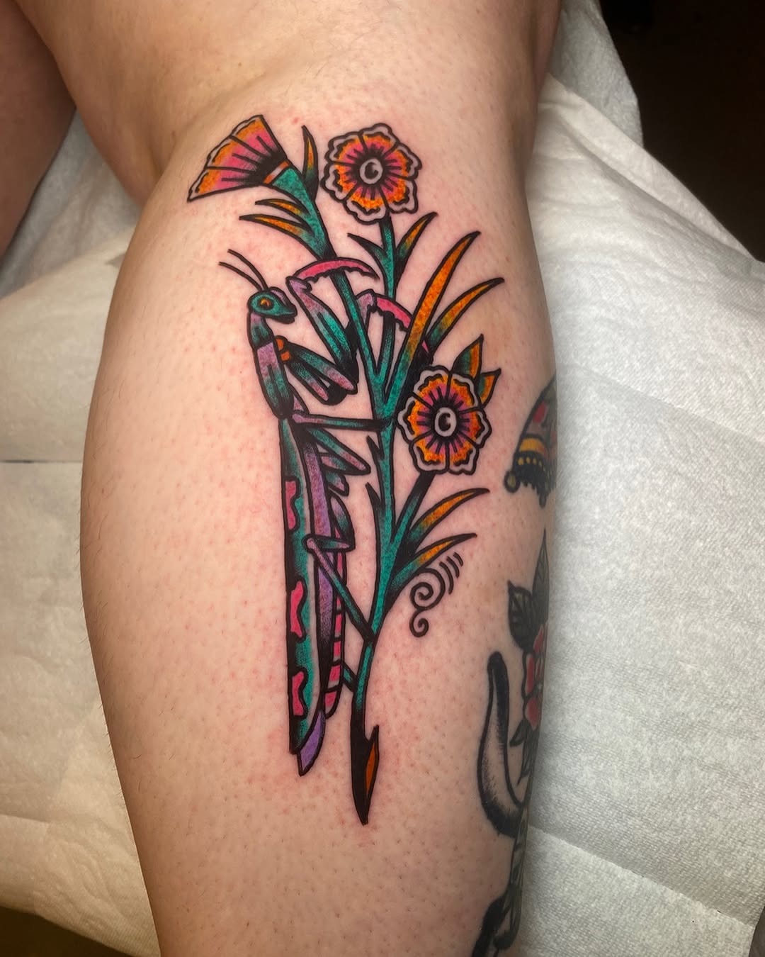 Vibrant praying mantis with floral elements Tattoo Design