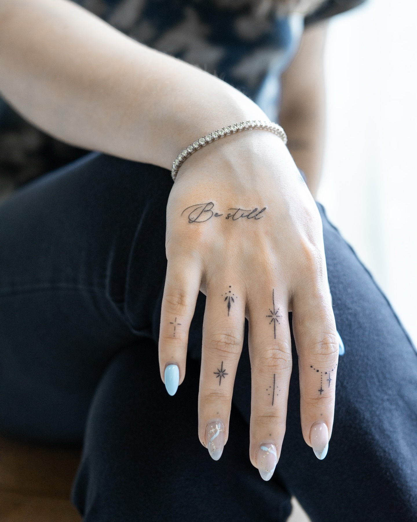 Be Still Script and Celestial Finger Tattoos Tattoo Design