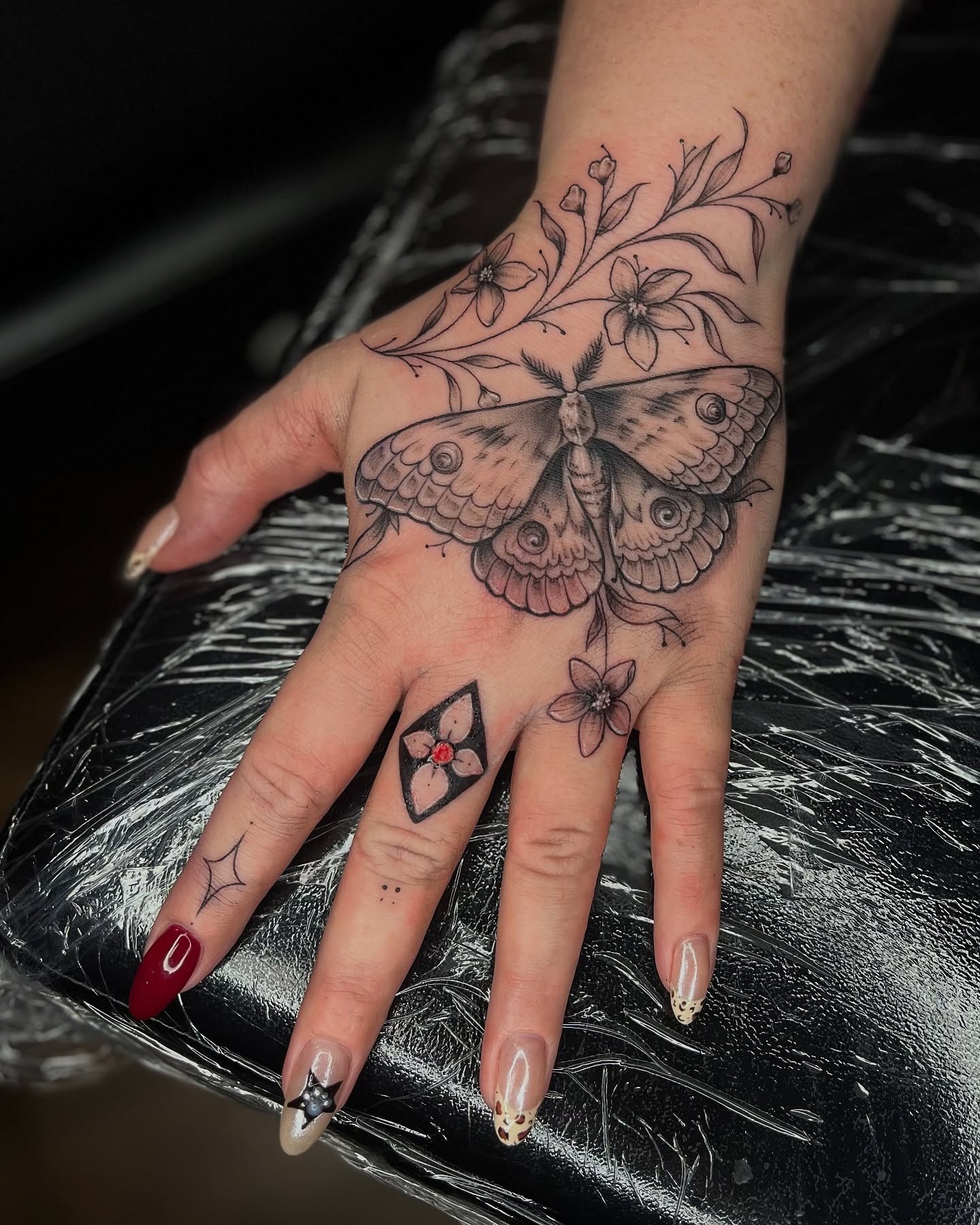 Large Moth and Floral Hand Tattoo Tattoo Design