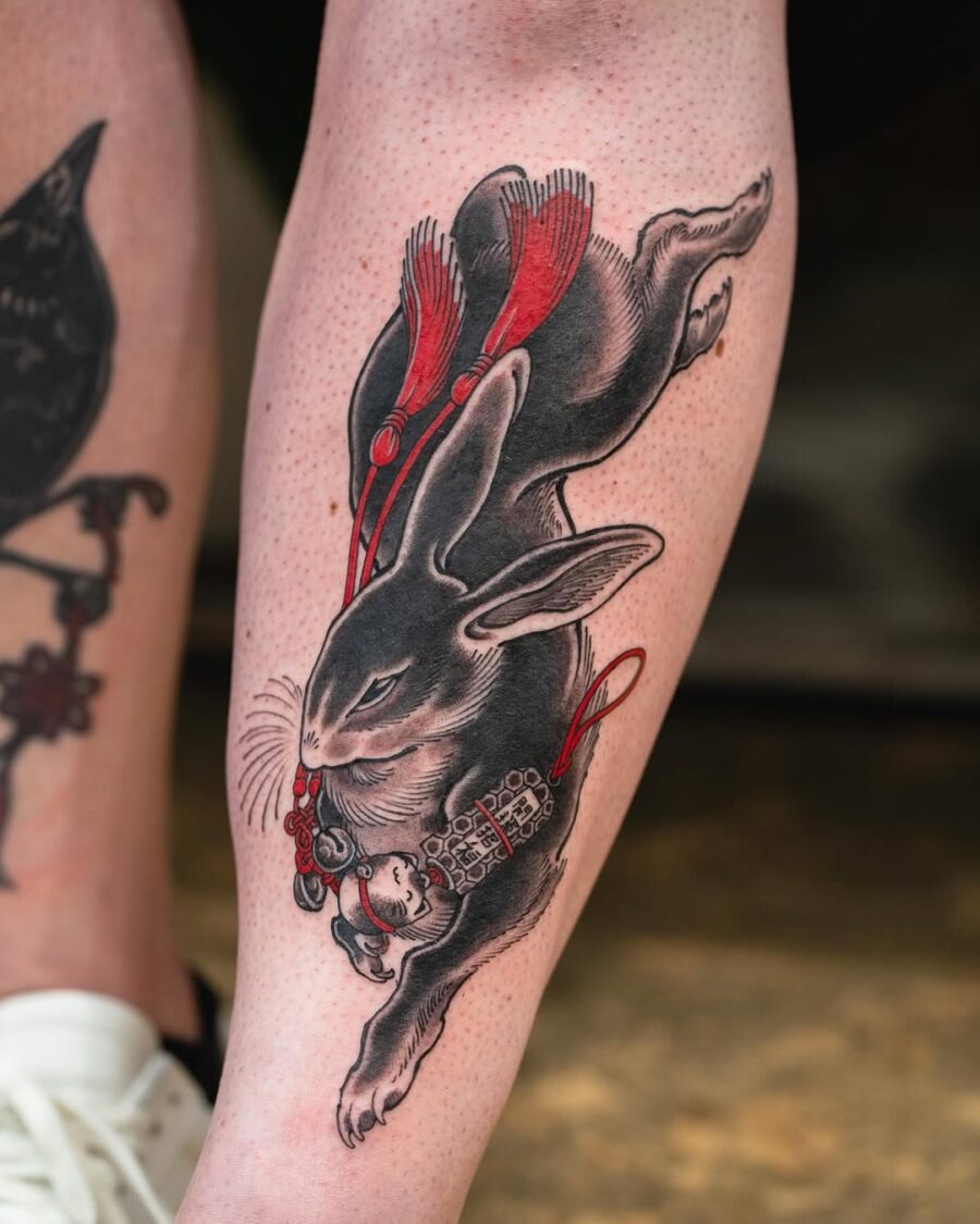 Dynamic rabbit tattoo with vibrant red accents Tattoo Design