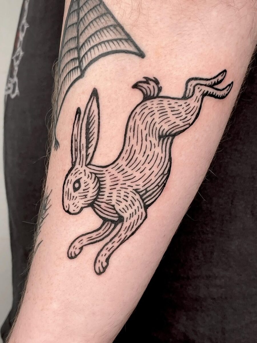 Playful leaping rabbit tattoo in black ink Tattoo Design