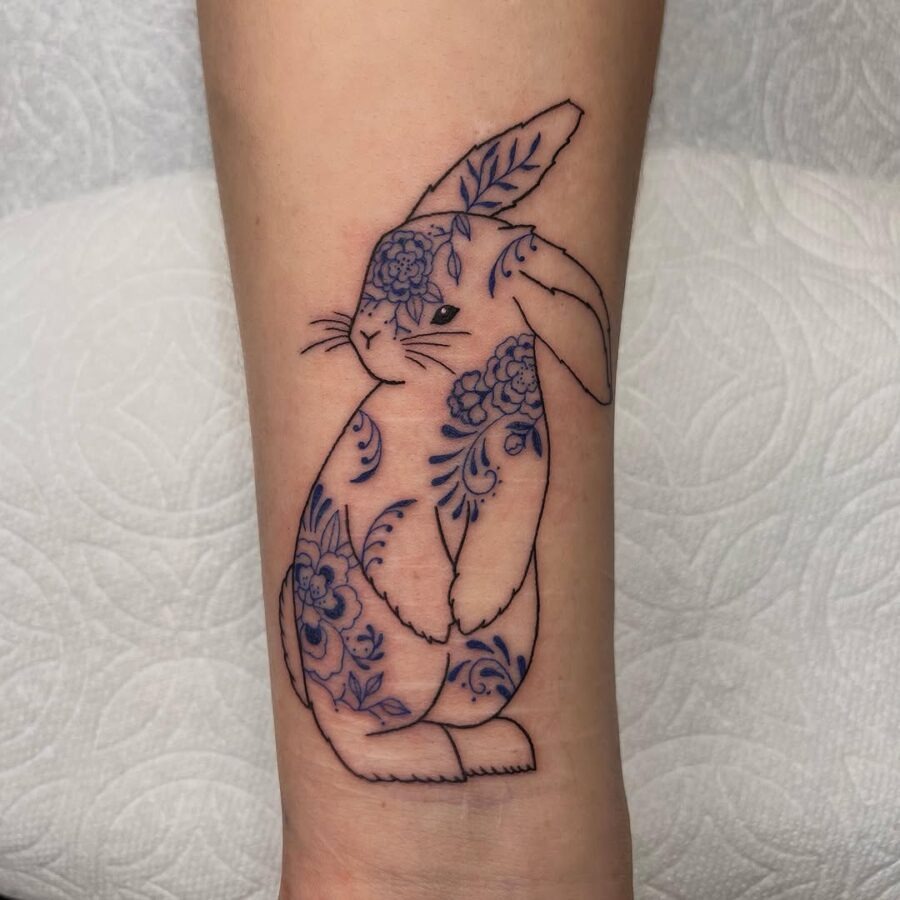 Whimsical rabbit tattoo with floral elements Tattoo Design