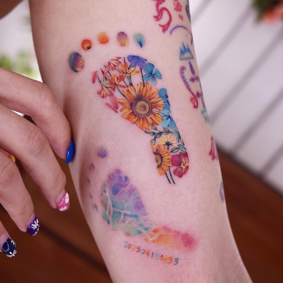 Vibrant rainbow baby footprints tattoo design Tattoo Design
