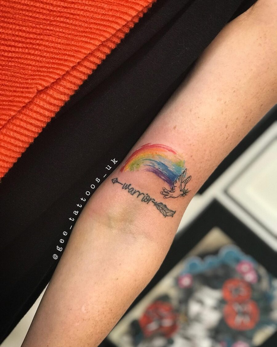 Vibrant rainbow baby tattoo with arrow design Tattoo Design