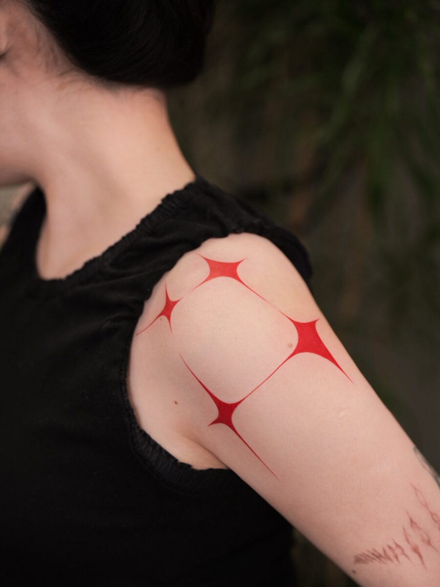 Bold red ink tattoo on hand showcases creativity Tattoo Design