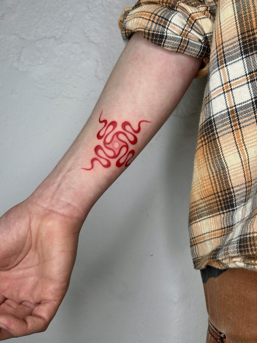 Elegant red ink initials on tattooed arm Tattoo Design