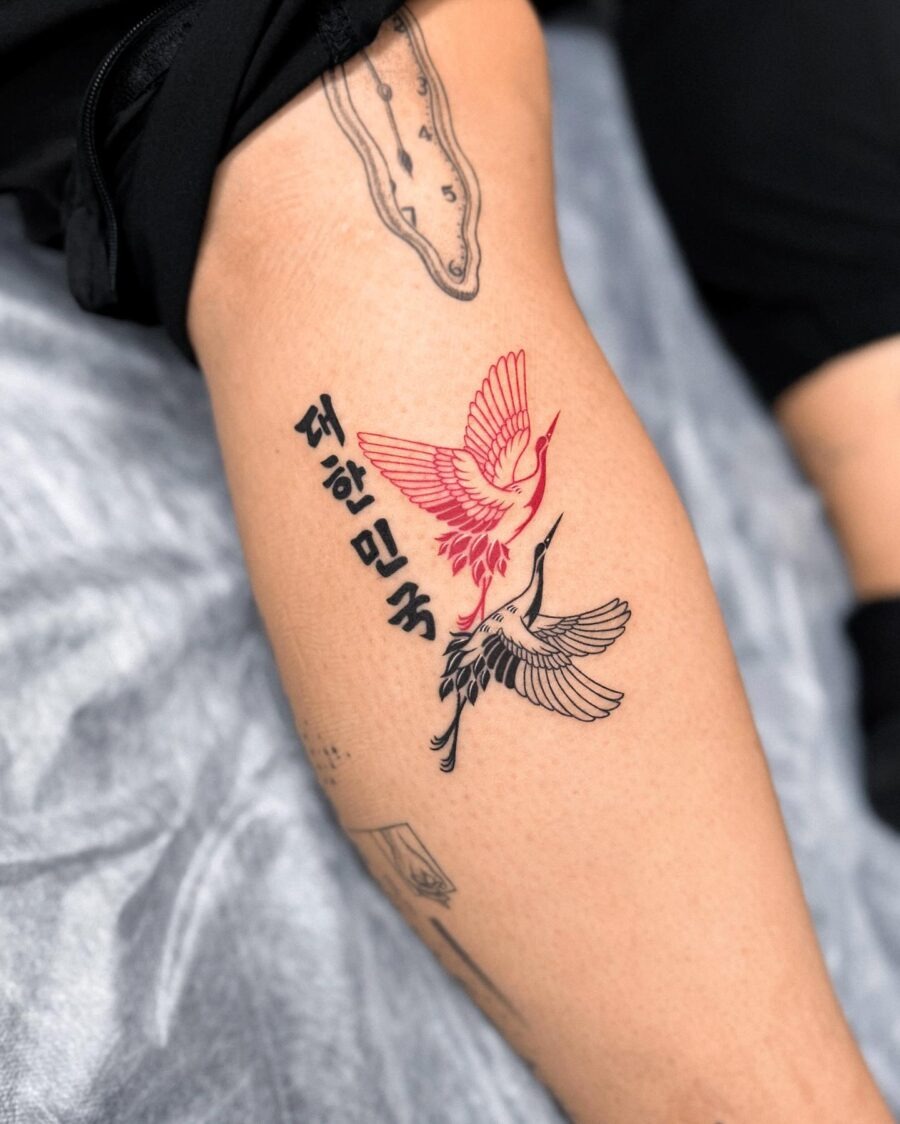Elegant red ink tattoo featuring cranes and blooms Tattoo Design