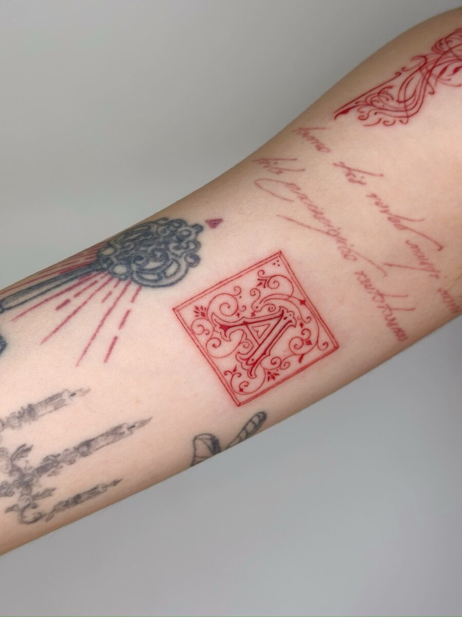 Elegant red ink tattoo with flowing lines Tattoo Design