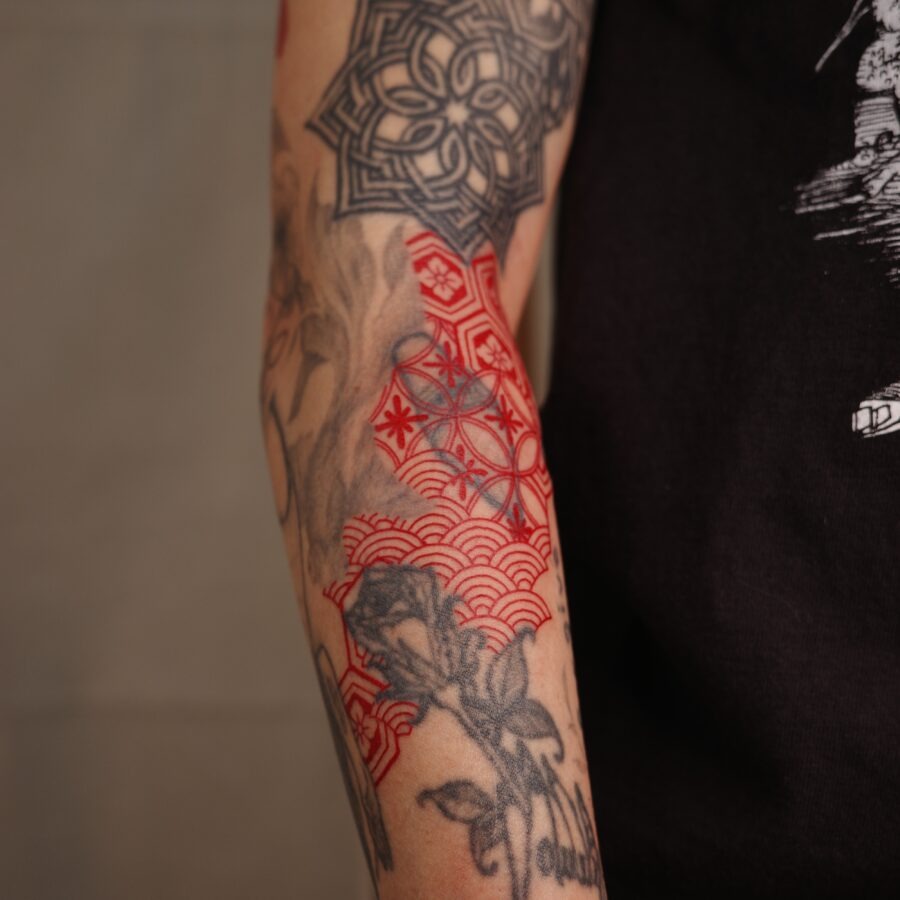 Intricate red ink tattoo featuring botanical elements Tattoo Design