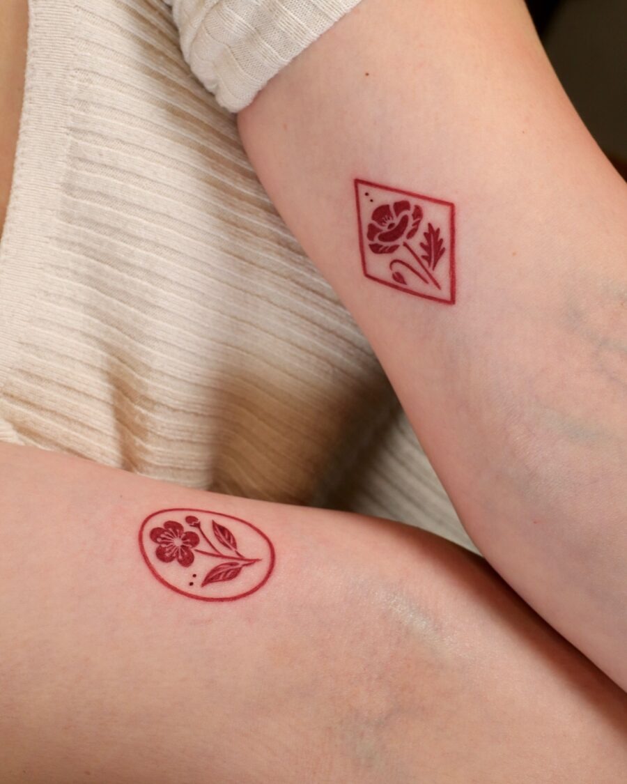 Vibrant red flower tattoo on the arm Tattoo Design