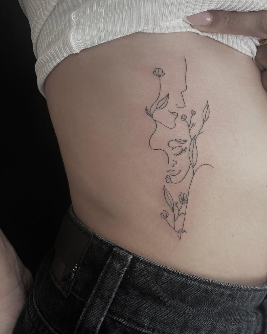 Artistic Rib Tattoo of Faces with Flowers Tattoo Design