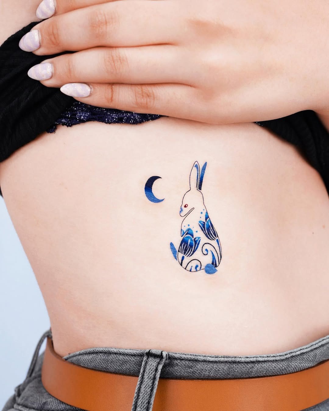Charming Rib Tattoo Featuring a Bunny and Moon Tattoo Design
