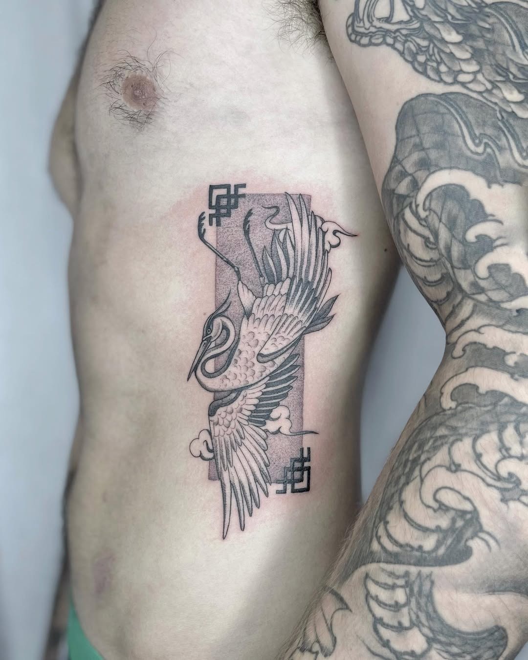 Elegant Crane Rib Tattoo in Black Ink Tattoo Design