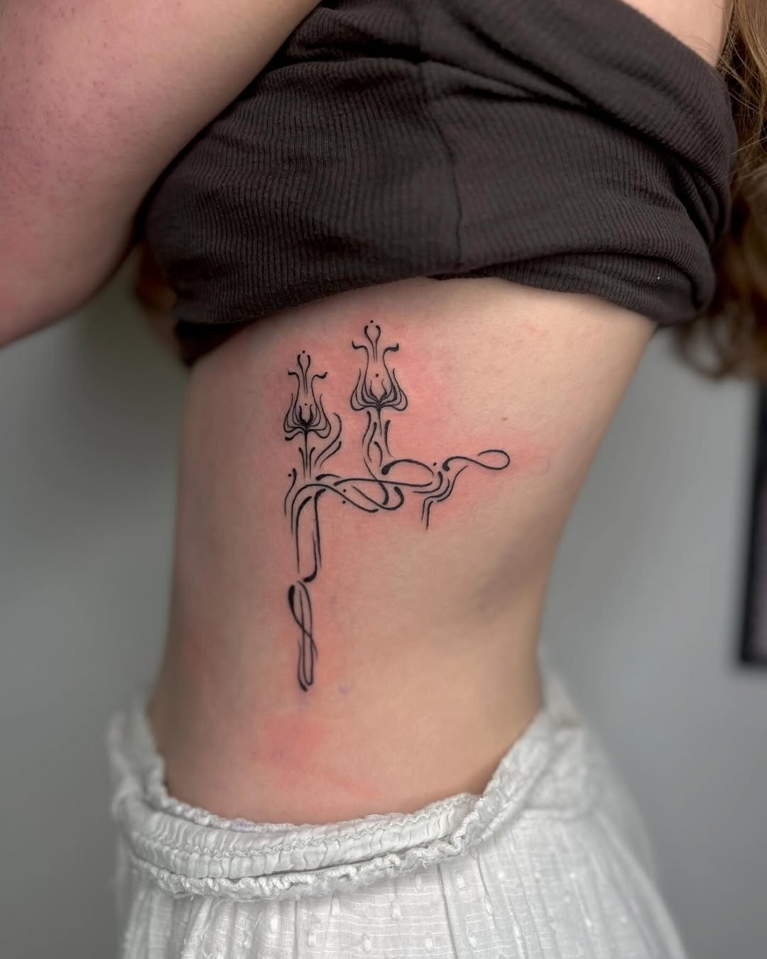 Elegant Rib Tattoo Design with Floral Lines Tattoo Design