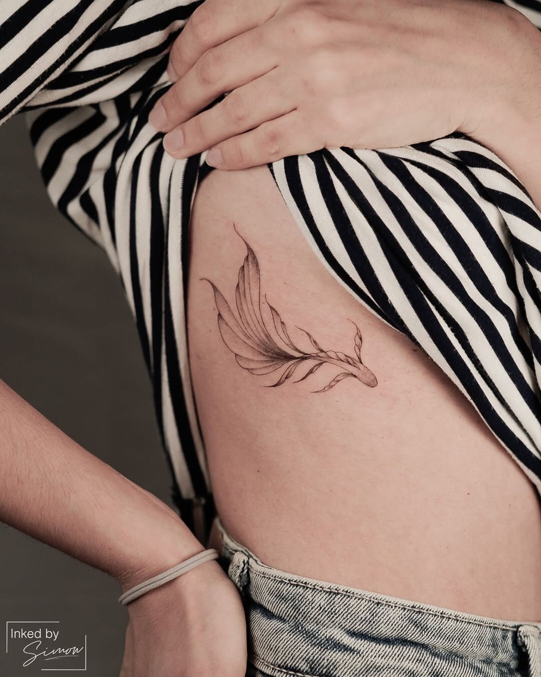 Elegant Rib Tattoo of a Feather Design Tattoo Design
