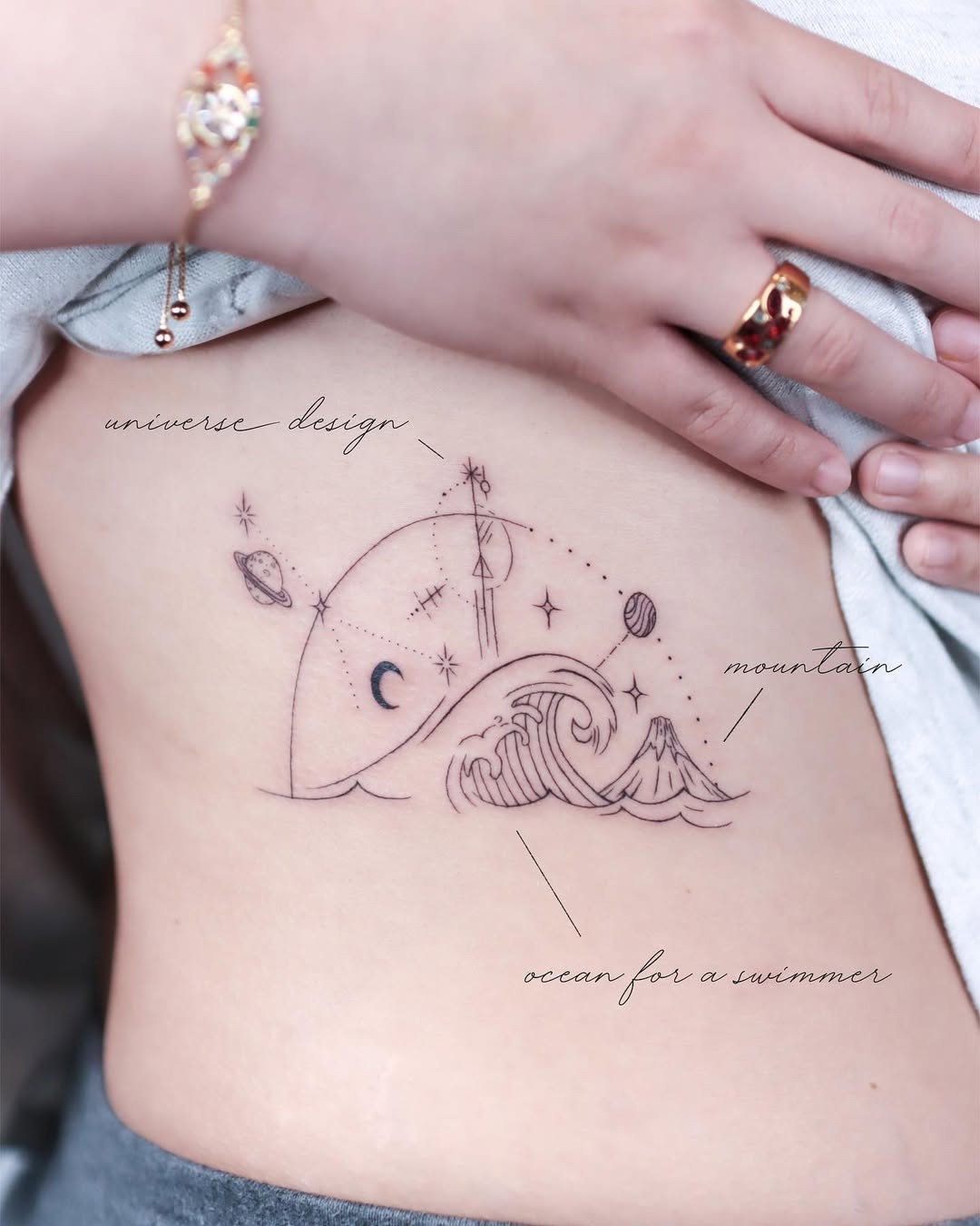 Elegant Rib Tattoo with Cosmic Elements Tattoo Design