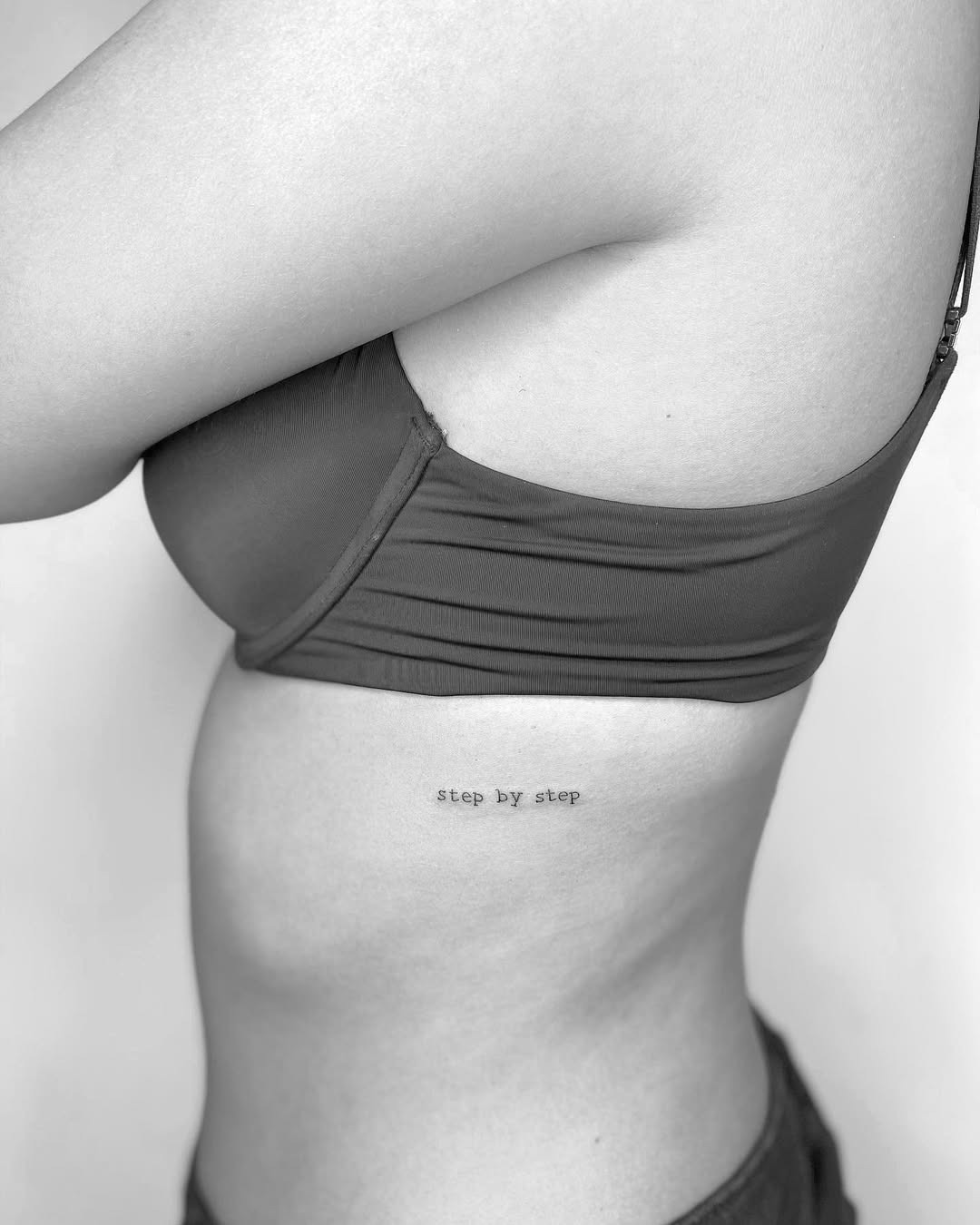 Elegant Rib Tattoo with Meaningful Phrase Tattoo Design