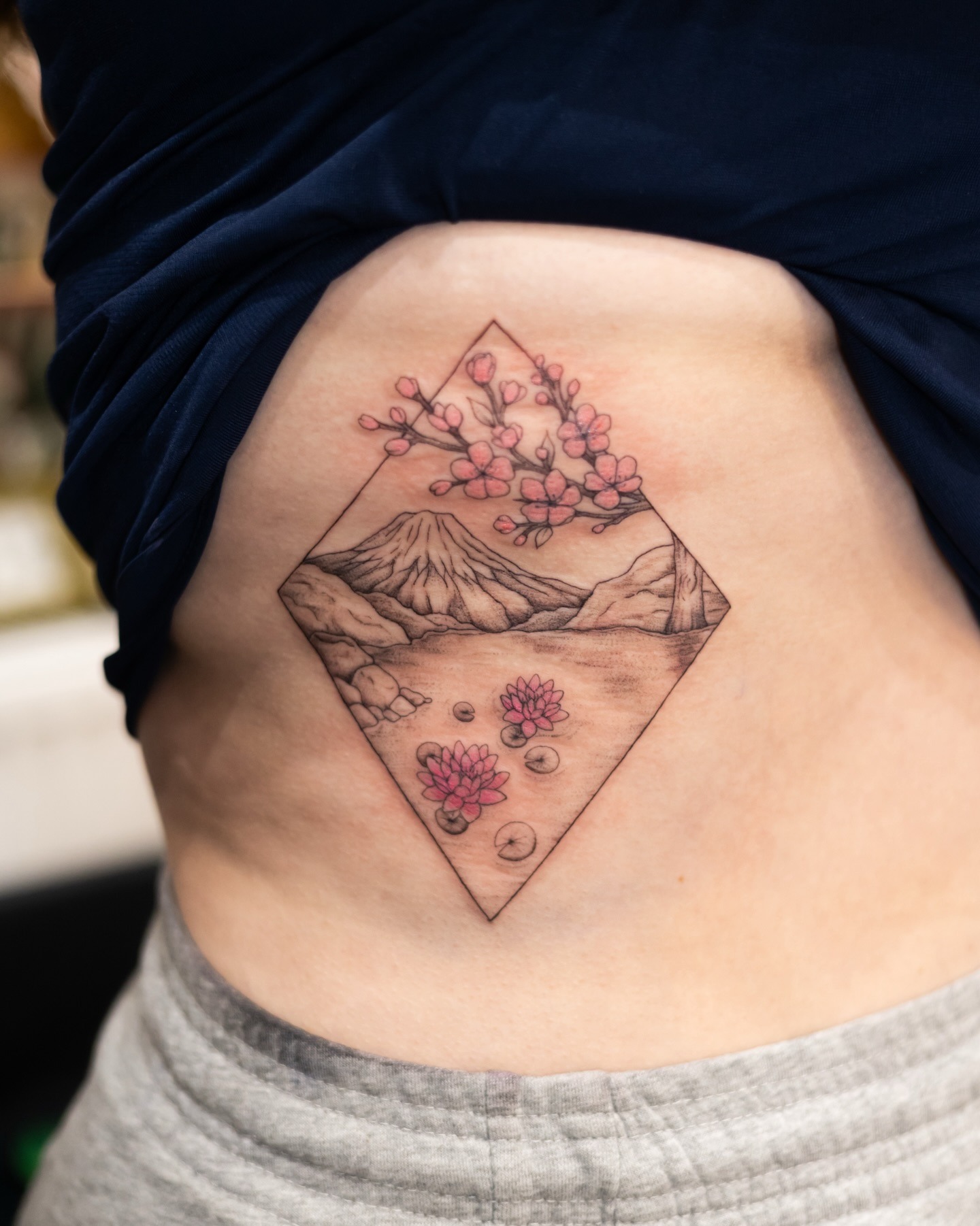 Mountain and Cherry Blossom Rib Tattoo Tattoo Design