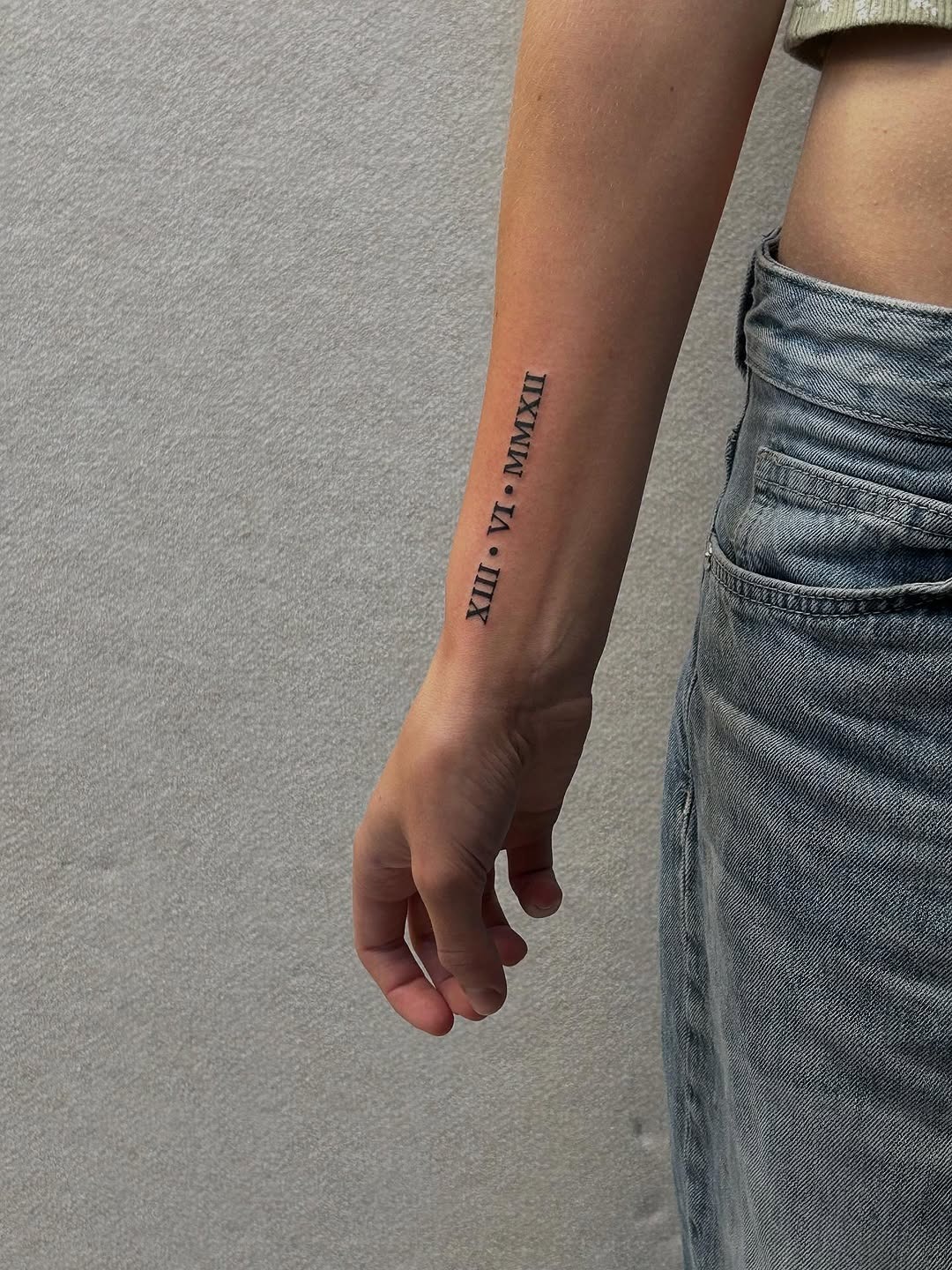 Elegant Roman Numerals on Forearm Tattoo Design