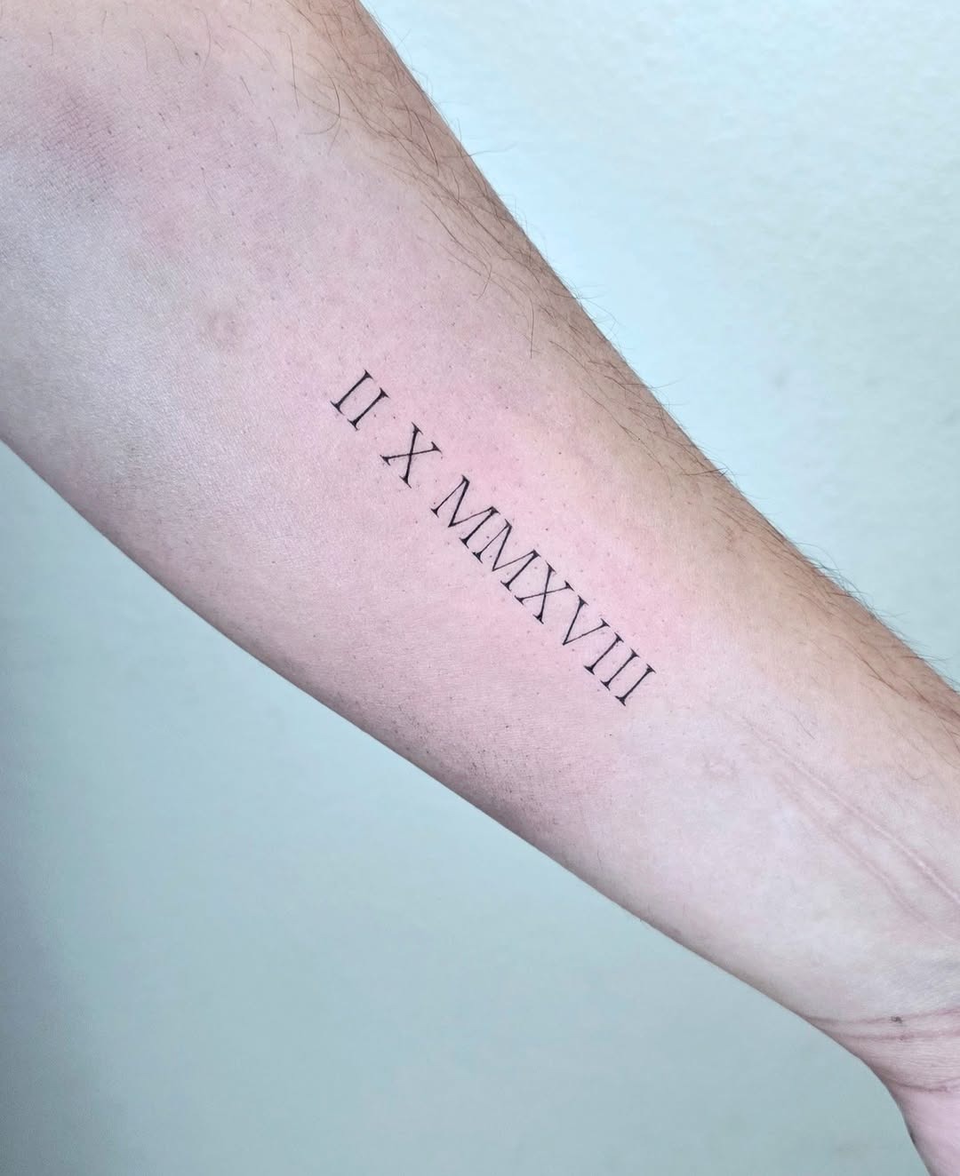 Minimalist Roman Numeral Tattoo on Forearm Tattoo Design