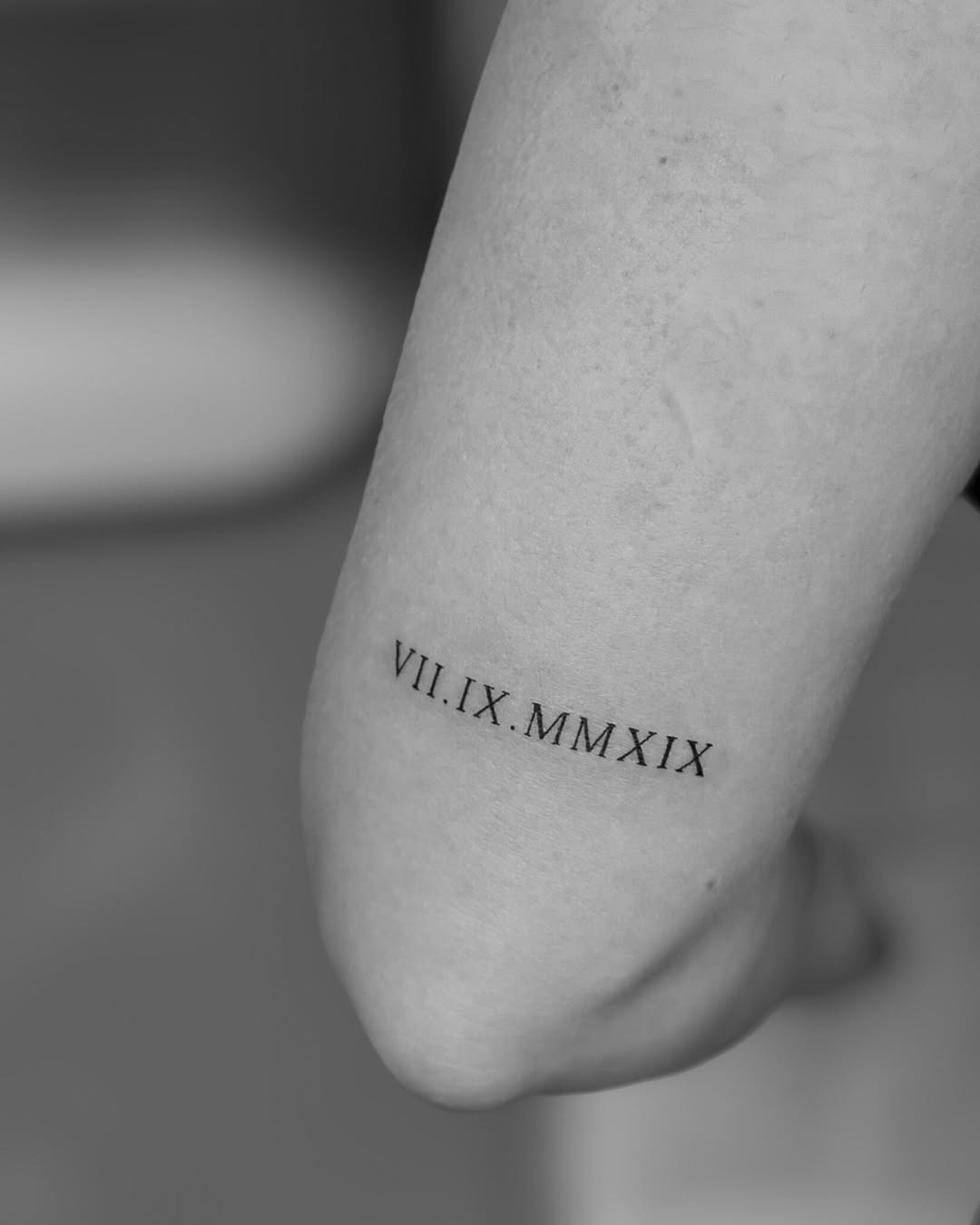 Minimalist roman numeral tattoo on the forearm Tattoo Design