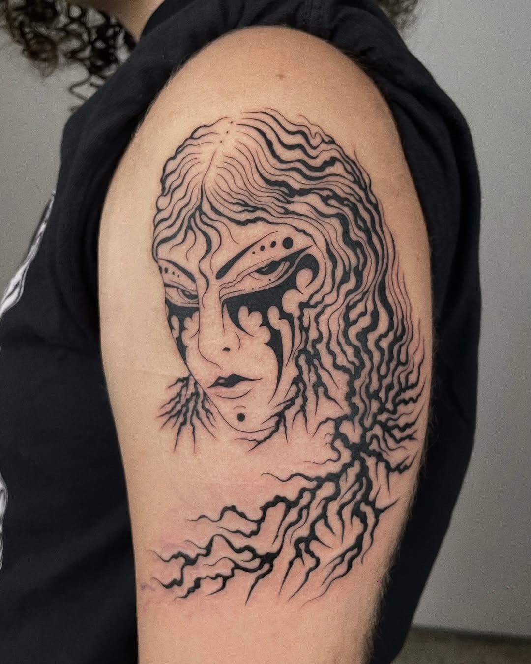 Intricate roots tattoo with enigmatic facial features Tattoo Design