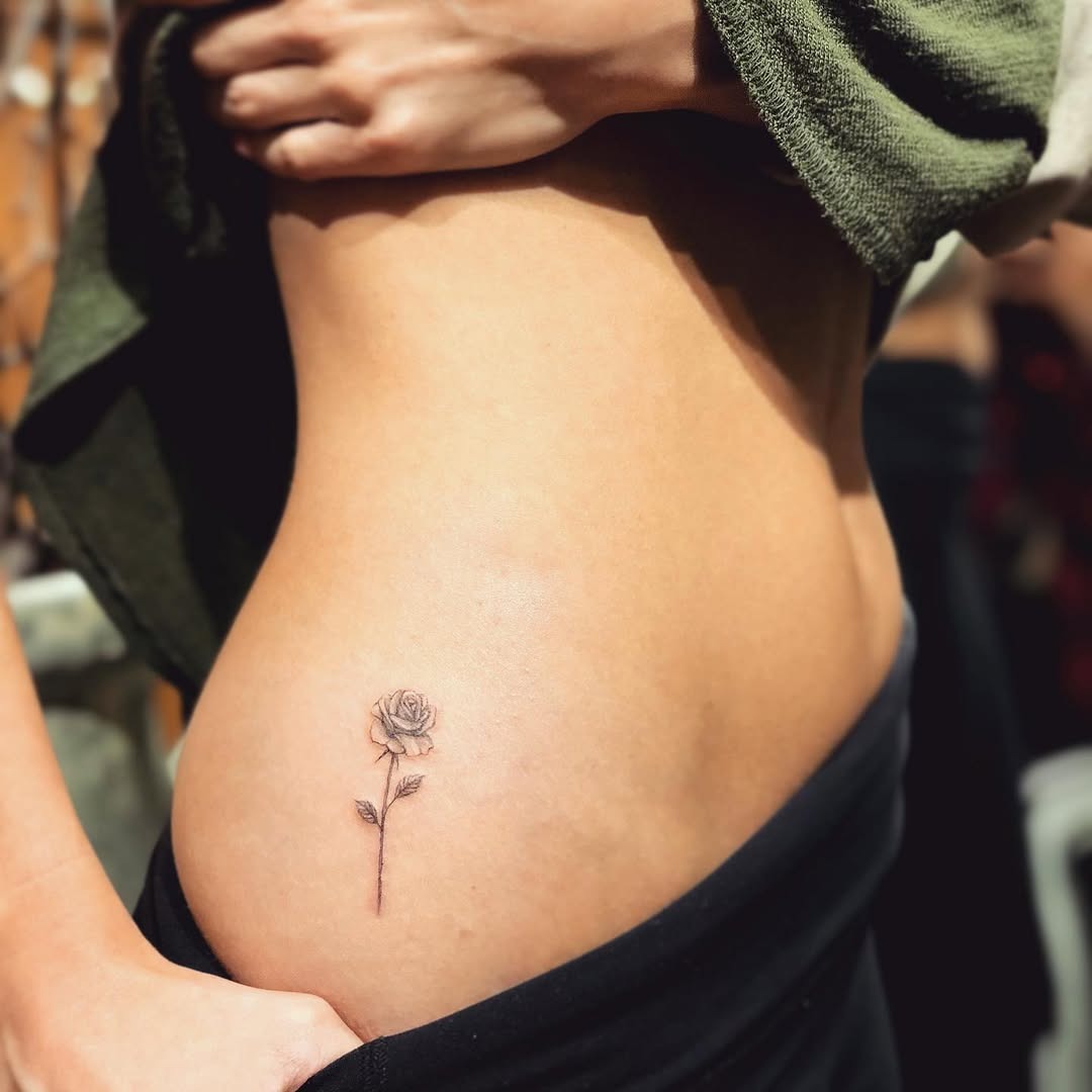 Delicate rose tattoo accentuating the curves Tattoo Design